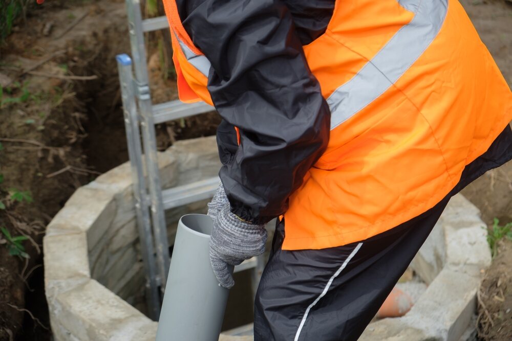 worker inspecting septic system pipes